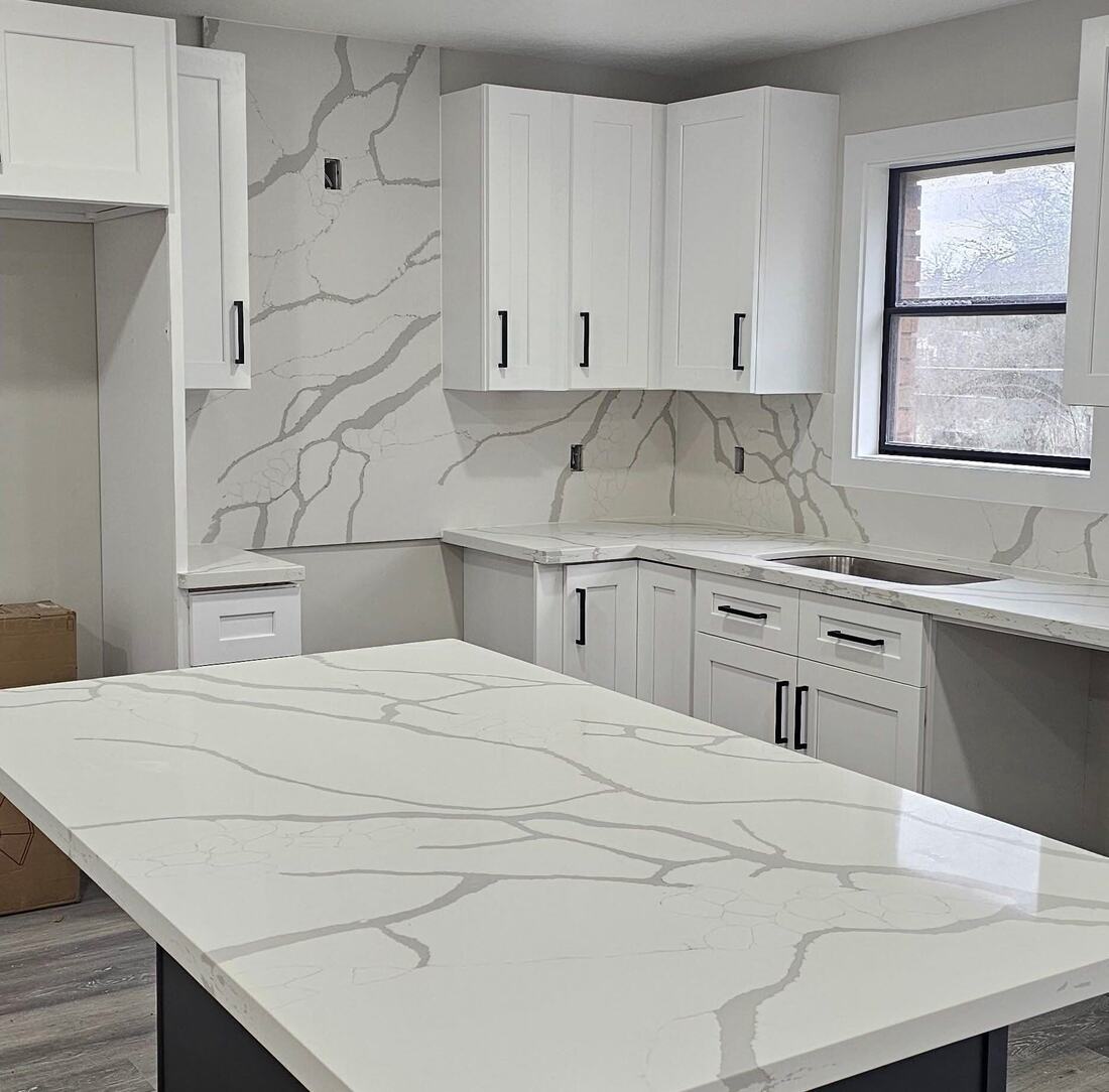White quartz island and full-slab backsplash with bold gray veining