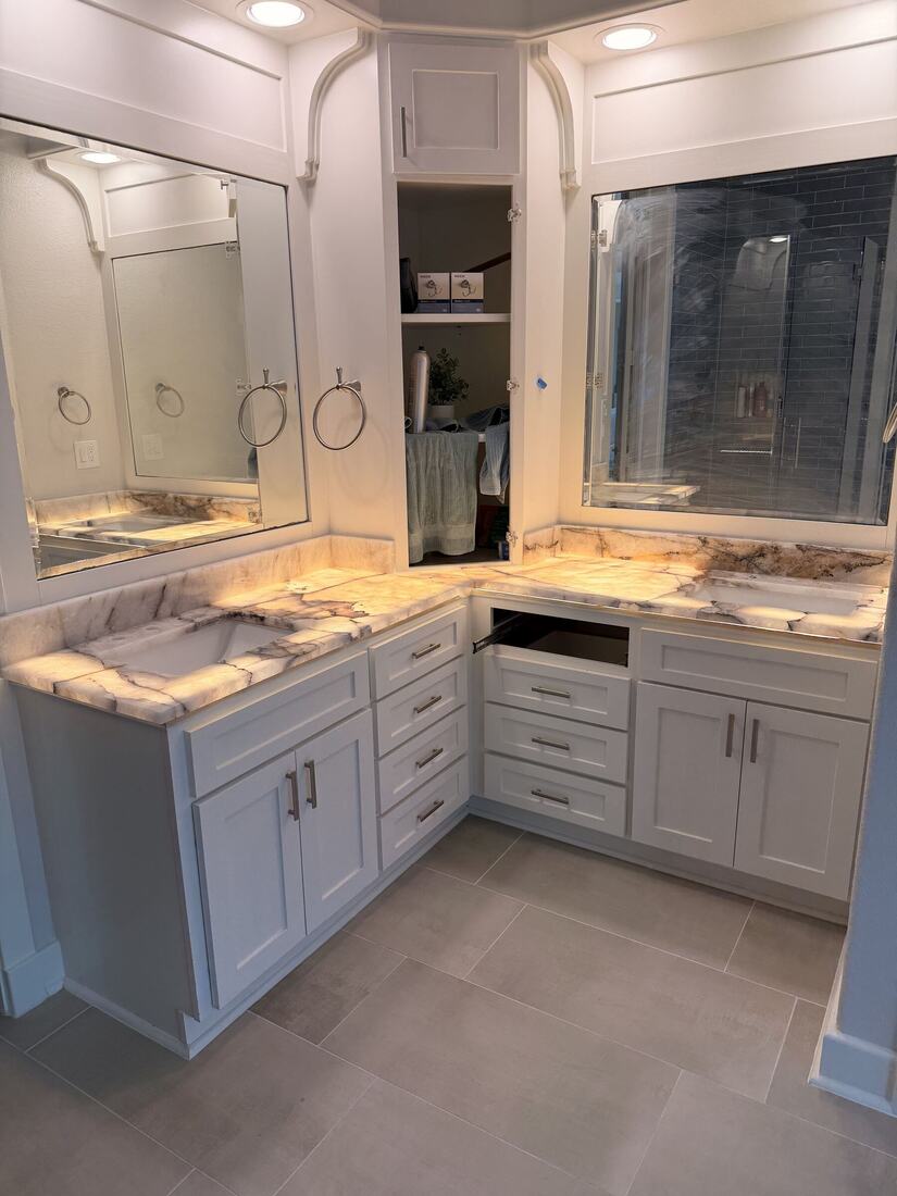 Double vanity in glowing exotic stone beneath large mirrors