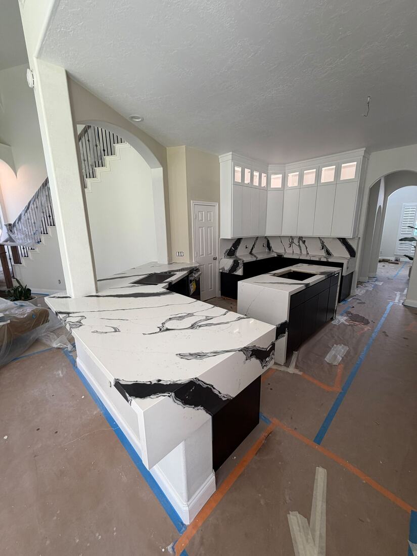 Mitered waterfall islands in white quartz with bold black veining