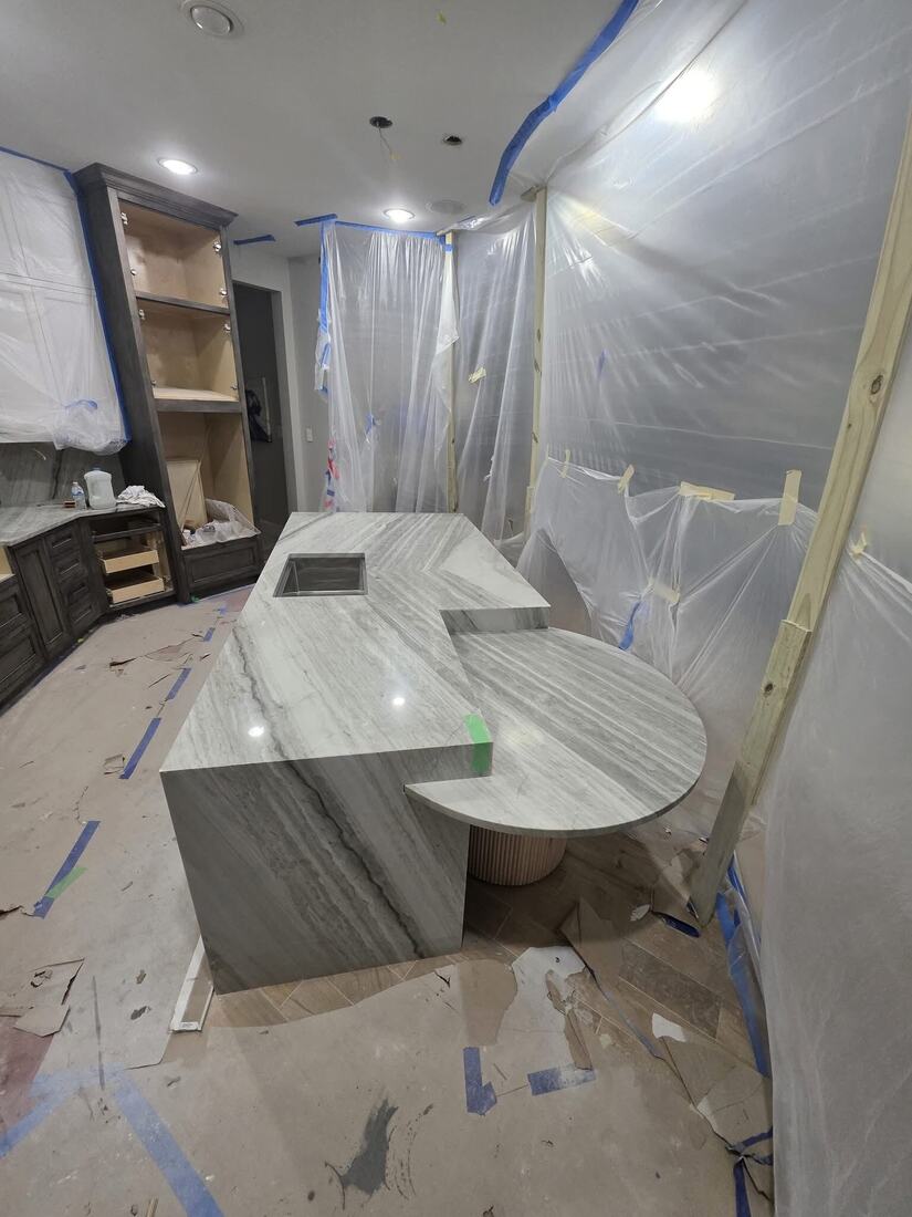 Quartzite waterfall island with a custom curved dining ledge
