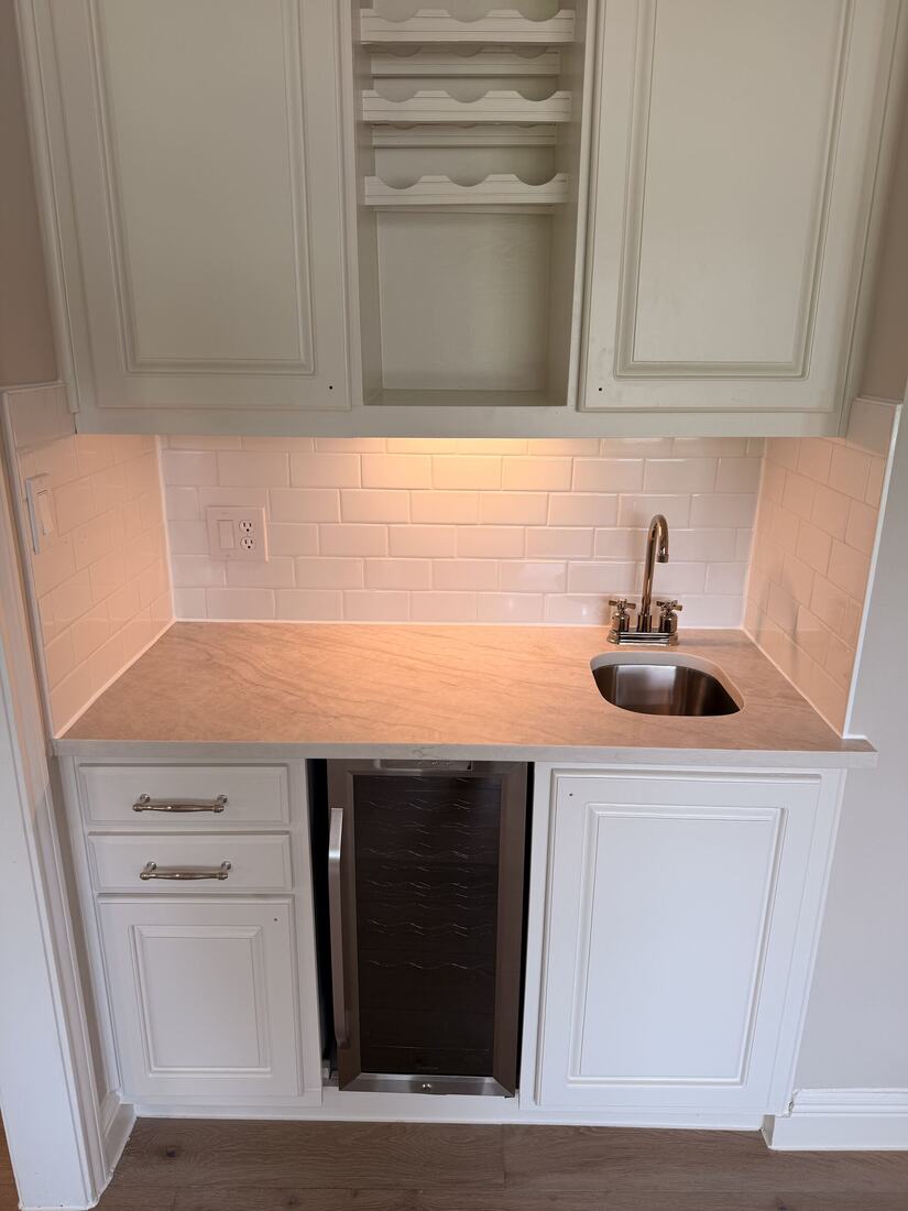 Quartzite wet bar with a subway tile backsplash and wine cooler